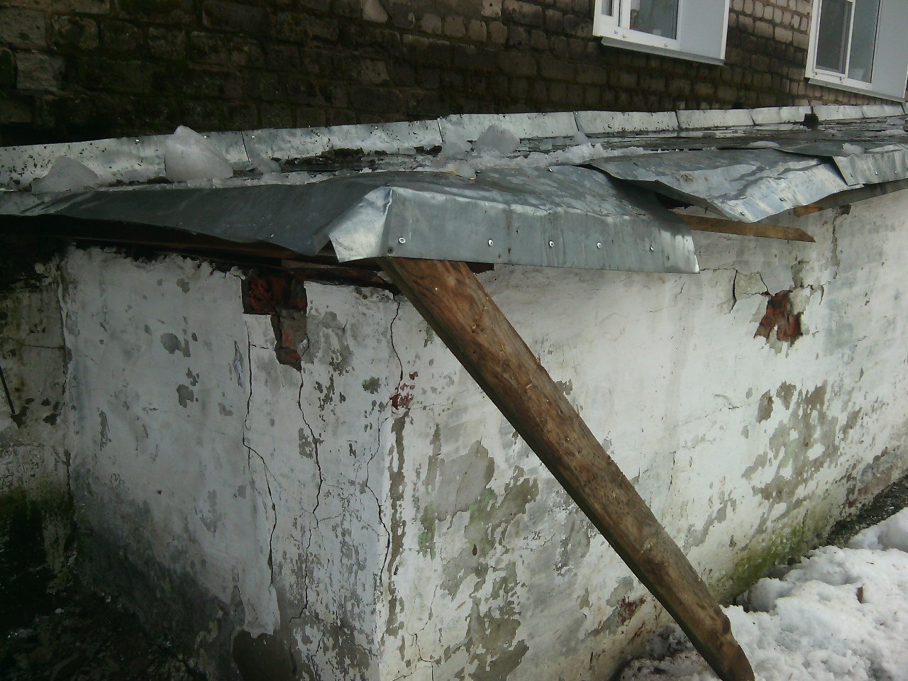 На Ленина коммунальщики чистили крышу от снега и повредили другую крышу